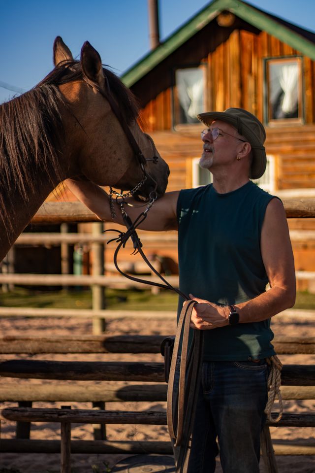 The author and his partner's horse, Cinnamon, standing face to face.